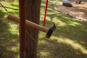 Tent camping metal hammer is hanging on a lantern pole. photo