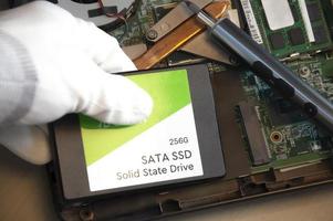 Technician installing ssd drive in old computer, upgrading computer photo