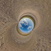 blue sphere little planet inside gravel road or field background. curvature of space photo