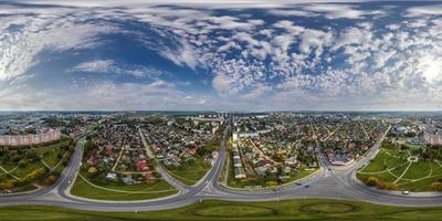 Vista aérea completa esférica hdri 360 panorámica sobre el cruce de carreteras con tráfico en una pequeña ciudad provincial con sector privado y edificios de apartamentos de gran altura en proyección equirectangular. foto