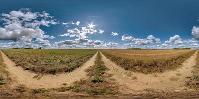 vista panorámica esférica completa hdri 360 sin tráfico en camino de grava sin tráfico entre campos con cielo nublado y nubes blancas en proyección equirectangular, puede usarse como reemplazo del cielo en panoramas foto