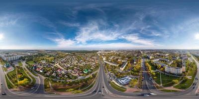 aerial full seamless spherical hdri 360 panorama view above road junction with traffic in small provincial town with private sector and high-rise apartment buildings in equirectangular projection. photo