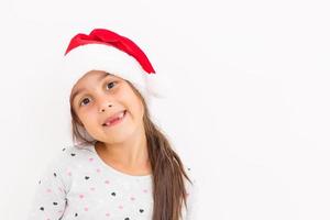 Cute little girl in the santa claus hat on a white background photo