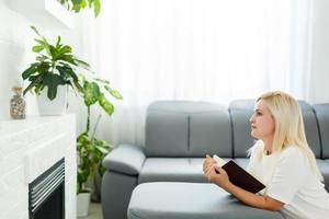 Girl praying. Side view of beautiful young blond hair woman praying at home photo