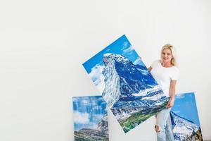 woman with a picture stands near the wall photo