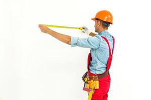 Worker in hard hat measure with ruler. Isolated on a white background. photo