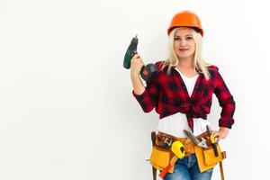 working woman in helmet with tools holding a drill photo