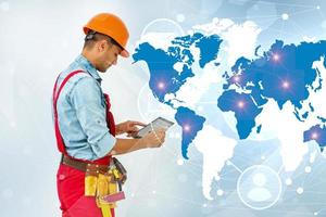 Side view man engineer wearing protective helmet using a tablet computer gadget choosing destinations on the world map. Modern technology artificial intelligence concept photo