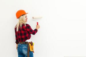 repair woman with a roller for painting walls photo