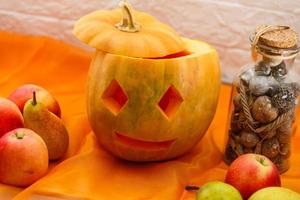 carved pumpkin for halloween lies on a table at home photo