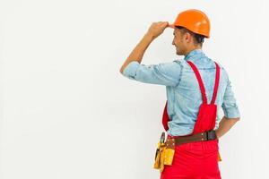 Portrait of cheerful young worker wearing hardhat over white background photo