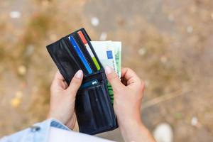 Female hands get money from a purse photo