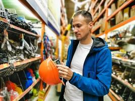 un hombre mide un casco en una tienda foto