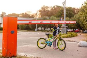 little girl on a bicycle bike near the barrier photo