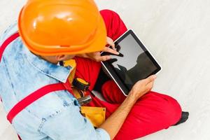 Builder Holding Digital Tablet On White Background. photo