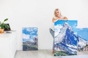 girl hangs a large photo canvas at home