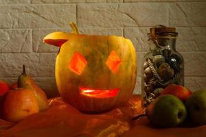 carved pumpkin for halloween lies on a table at home photo