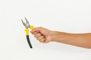 The hand of the mechanic is holding a plier isolated on white background with clipping paths. photo