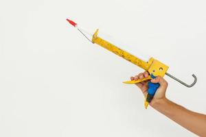 Hand holding glue gun isolated on the white background photo