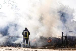 Firefighters extinguish a fire in forest by water flooding photo