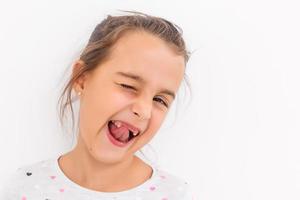 Little girl first tooth missing on a white background photo