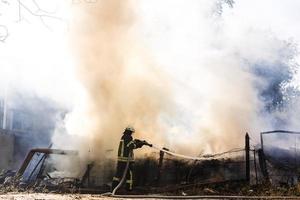 Firefighters extinguish a fire in forest by water flooding photo