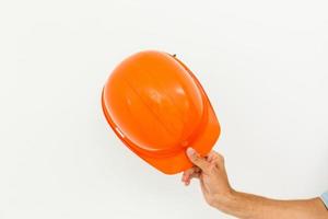 mano masculina con casco de seguridad amarillo. Mano humana sosteniendo casco, aislado sobre fondo blanco. foto