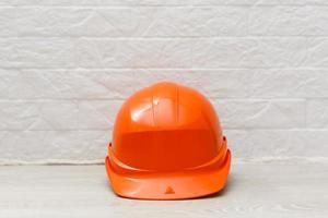 casco naranja para trabajador constructor aislado en blanco foto