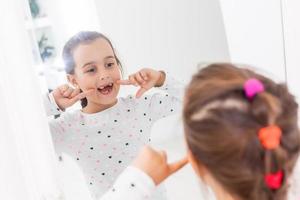 little girl smiling mirror teeth photo