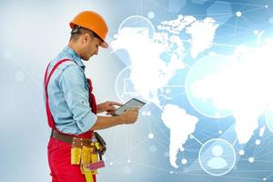 Side view man engineer wearing protective helmet using a tablet computer gadget choosing destinations on the world map. Modern technology artificial intelligence concept photo