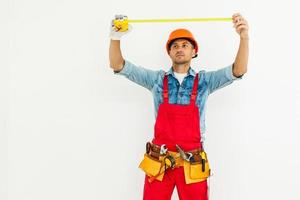 The builder in a helmet with a tape measure photo