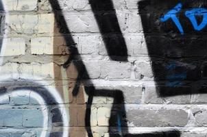 Fragment of graffiti drawings. The old wall decorated with paint stains in the style of street art culture. Colored background texture photo