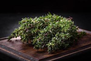 Bunch of fresh picked thyme on a dark concrete background photo