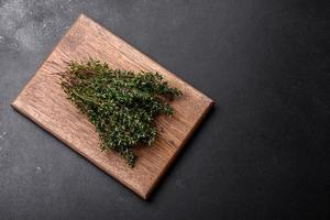 Bunch of fresh picked thyme on a dark concrete background photo