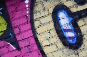 fragmento de dibujos de graffiti. la antigua muralla decorada con manchas de pintura al estilo de la cultura del arte callejero. textura de fondo de color foto