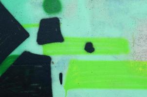 Background image with a colored graffiti pattern, which is applied to the concrete wall with aerosol paints. A lot of contours and fragments filled with paint, forming an interesting composition photo
