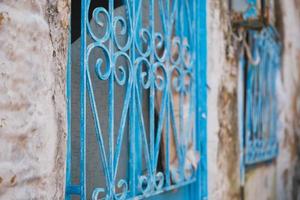 Metal grating painted with blue paint on an old house, selective focus on bars, ideas for a background or interior, renovation of old houses photo