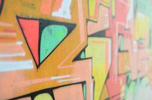 Background image with a colored graffiti pattern, which is applied to the concrete wall with aerosol paints. A lot of contours and fragments filled with paint, forming an interesting composition photo