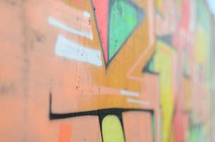 Background image with a colored graffiti pattern, which is applied to the concrete wall with aerosol paints. A lot of contours and fragments filled with paint, forming an interesting composition photo