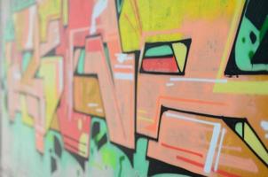 Background image with a colored graffiti pattern, which is applied to the concrete wall with aerosol paints. A lot of contours and fragments filled with paint, forming an interesting composition photo