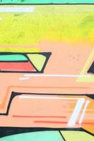 Background image with a colored graffiti pattern, which is applied to the concrete wall with aerosol paints. A lot of contours and fragments filled with paint, forming an interesting composition photo