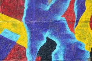 Fragment of graffiti drawings. The old wall decorated with paint stains in the style of street art culture. Multicolored background texture photo
