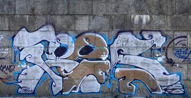 fragmento de dibujos de graffiti. la antigua muralla decorada con manchas de pintura al estilo de la cultura del arte callejero. textura de fondo coloreada en tonos cálidos foto