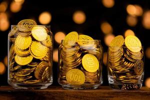 moneda de oro en botella de vidrio, concepto de ahorro de dinero y ahorro de oro foto