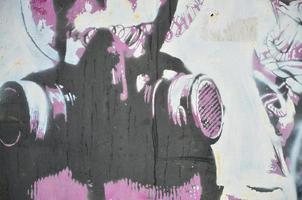 la antigua muralla, pintada en color dibujo de graffiti con pinturas en aerosol. imagen de una máscara de gas en un estilo de plantilla foto
