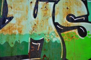 The old wall, painted in color graffiti drawing green aerosol paints. Background image on the theme of drawing graffiti and street art photo