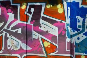 The old wall, painted in color graffiti drawing red aerosol paints. Background image on the theme of drawing graffiti and street art photo