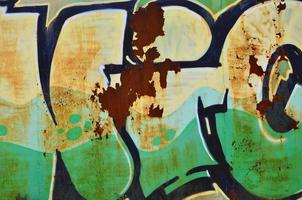 The old wall, painted in color graffiti drawing green aerosol paints. Background image on the theme of drawing graffiti and street art photo