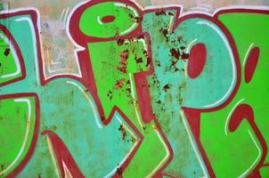 The old wall, painted in color graffiti drawing green aerosol paints. Background image on the theme of drawing graffiti and street art photo
