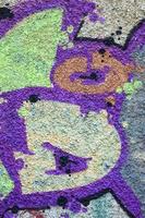 Fragment of graffiti drawings. The old wall decorated with paint stains in the style of street art culture. Colored background texture in warm tones photo